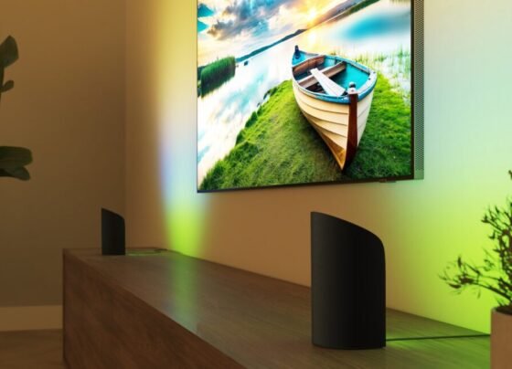 Two Philips Hue Play devices facing a wall that has a TV mounted to it.