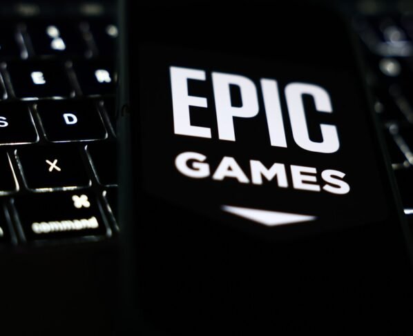 A laptop keyboard and Epic Games logo displayed on a phone screen are seen in this illustration photo taken in Krakow, Poland on October 1, 2024. (Photo by Jakub Porzycki/NurPhoto via Getty Images)