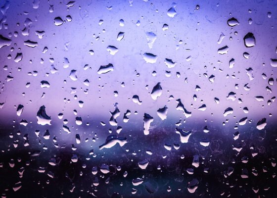 Gotas de água formadas em uma superfície de vidro mais fria, um exemplo de condensação.